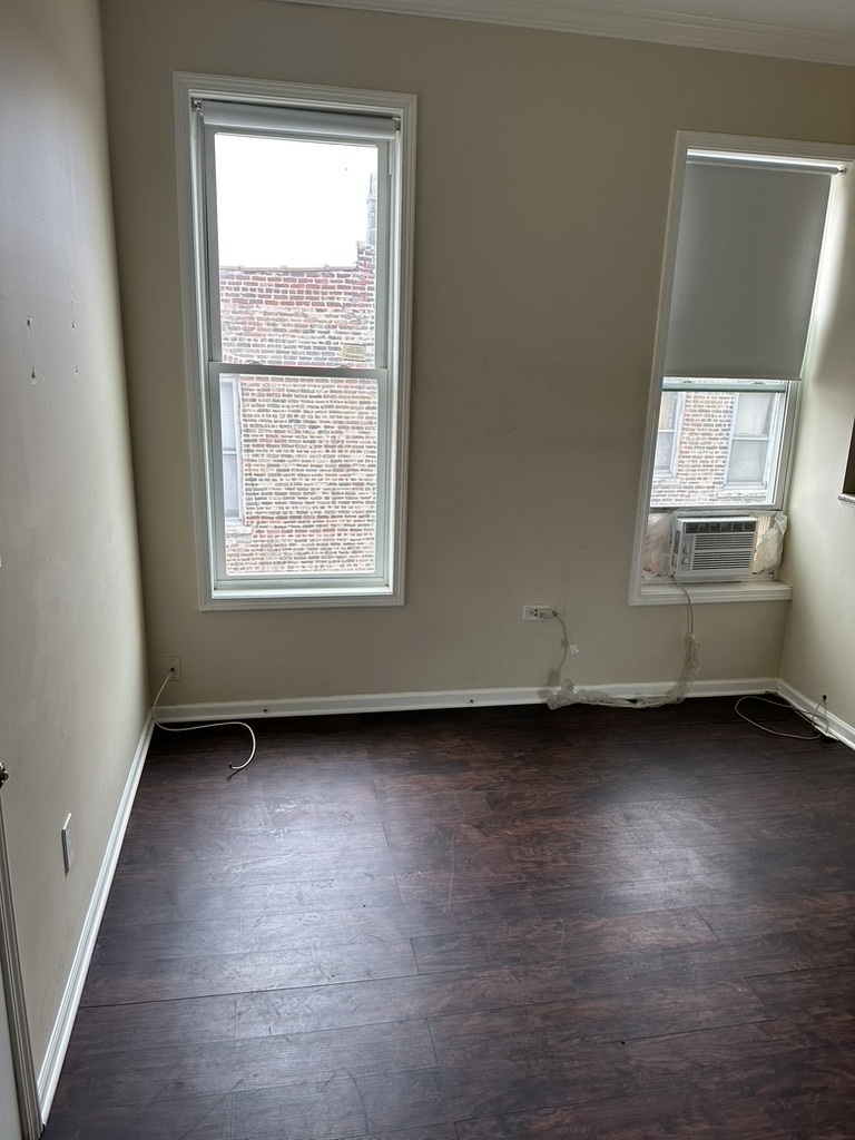 321 West 24th Street, Unit 3R Chicago, IL 60616 - Photo 9 of 11 an empty room with wooden floor and windows