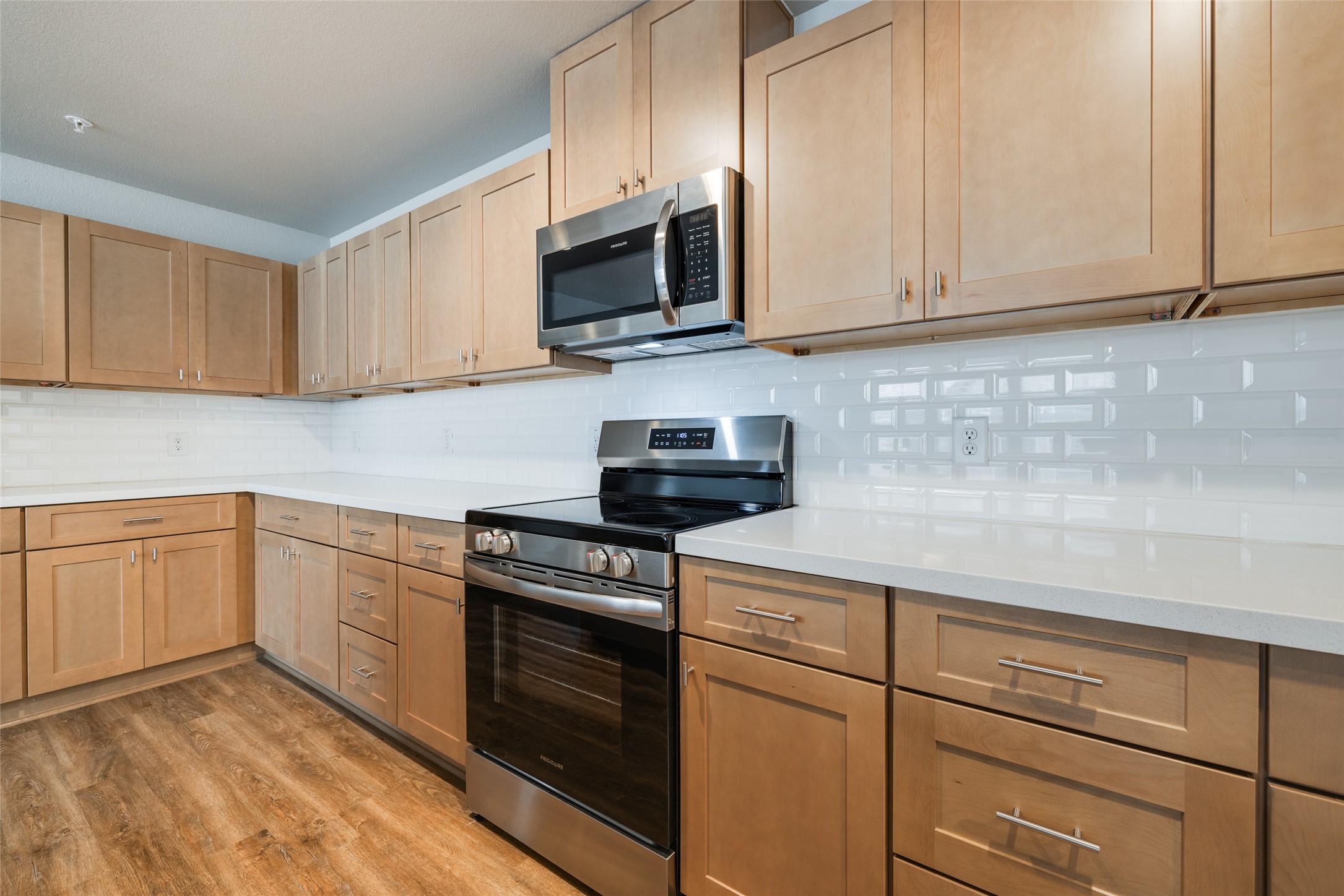 239 Park Place Circle, Unit D Waller, TX 77484 - Photo 11 of 17 a kitchen with granite countertop white cabinets and black appliances