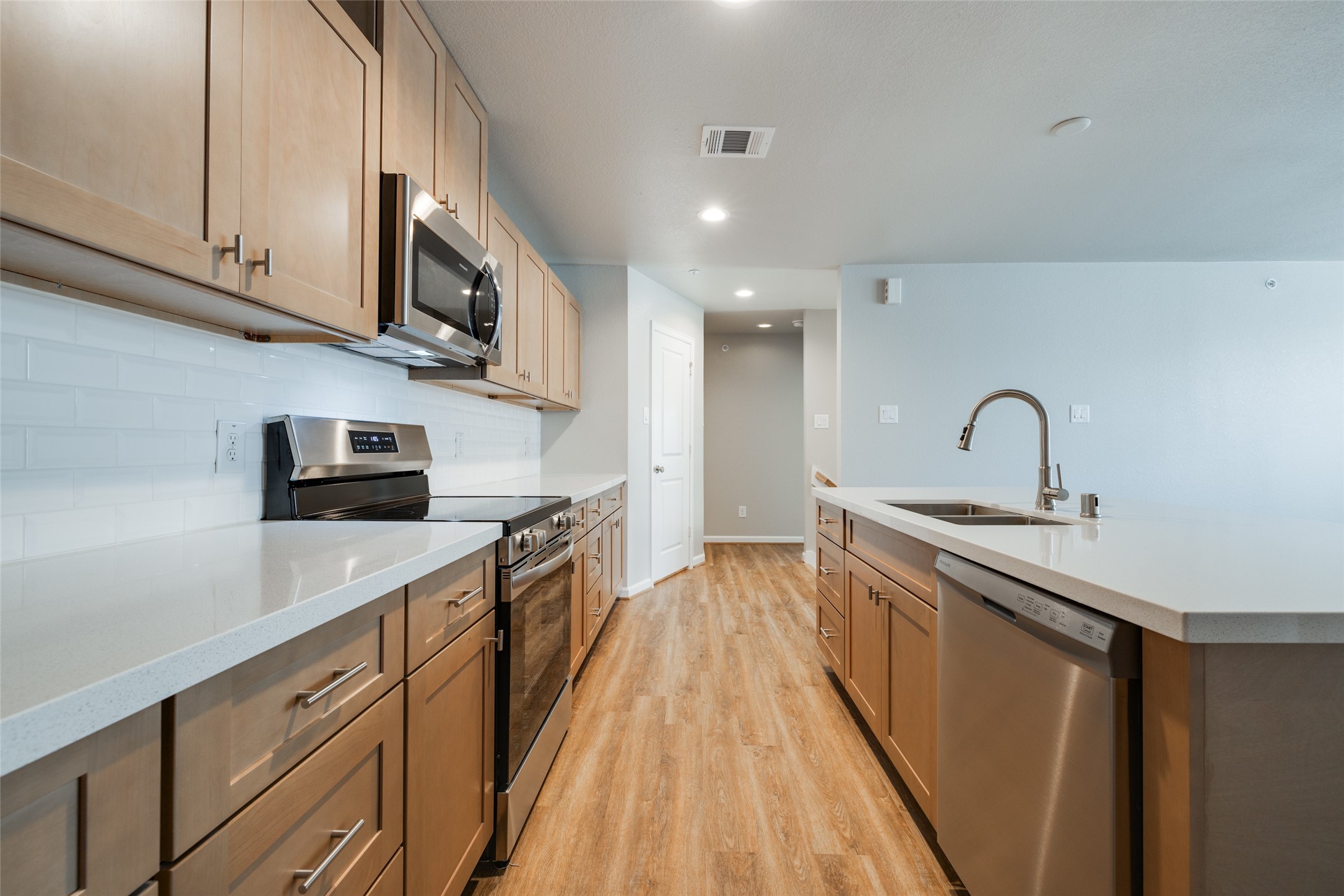 239 Park Place Circle, Unit D Waller, TX 77484 - Photo 12 of 17 a kitchen with stainless steel appliances granite countertop a sink stove and microwave