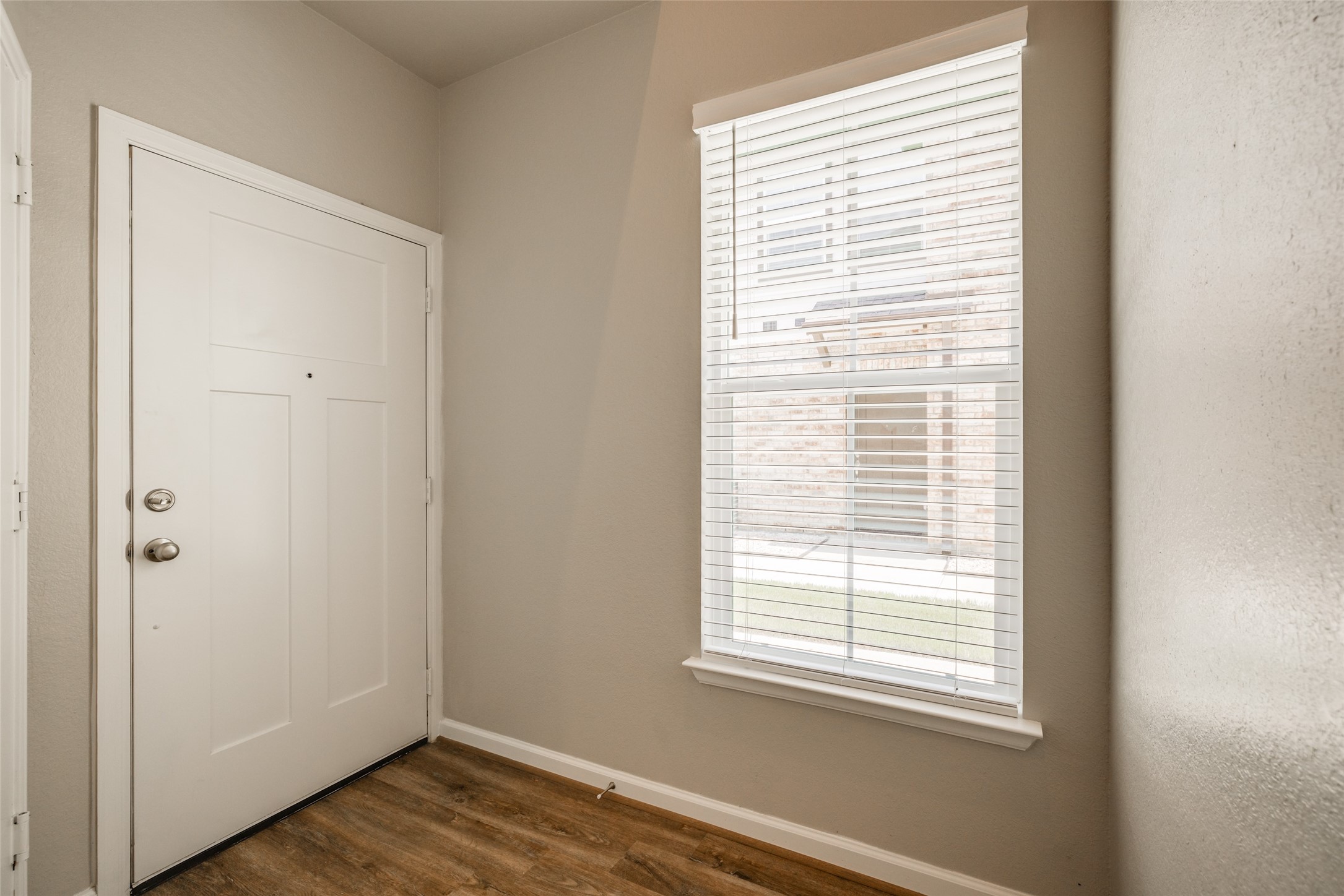 239 Park Place Circle, Unit D Waller, TX 77484 - Photo 3 of 17 a view of an empty room with wooden floor and a window