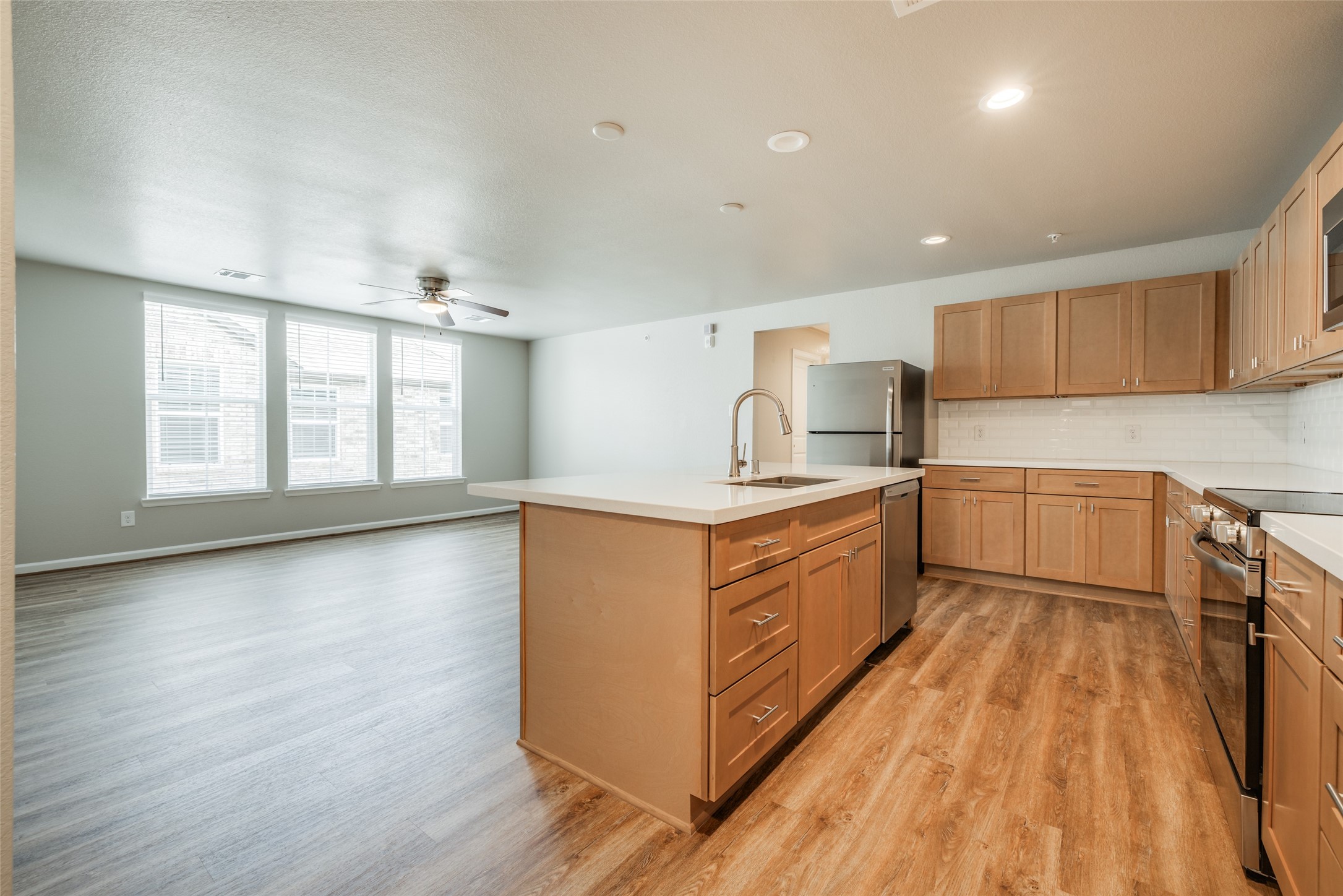 239 Park Place Circle, Unit D Waller, TX 77484 - Photo 5 of 17 a kitchen with stainless steel appliances granite countertop a stove a sink and a refrigerator