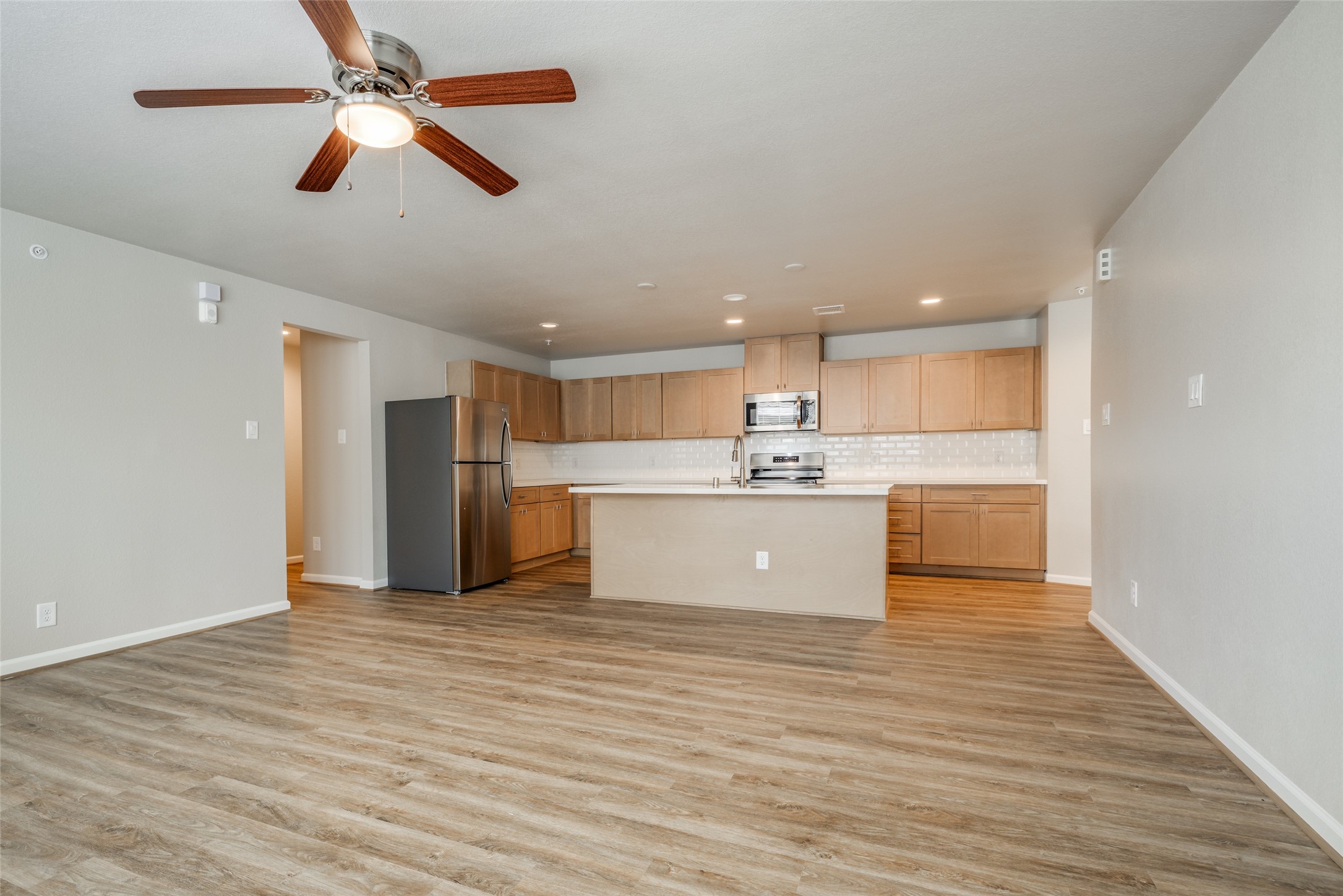 239 Park Place Circle, Unit D Waller, TX 77484 - Photo 6 of 17 a view of kitchen with stainless steel appliances kitchen island a sink a refrigerator and a view of living room