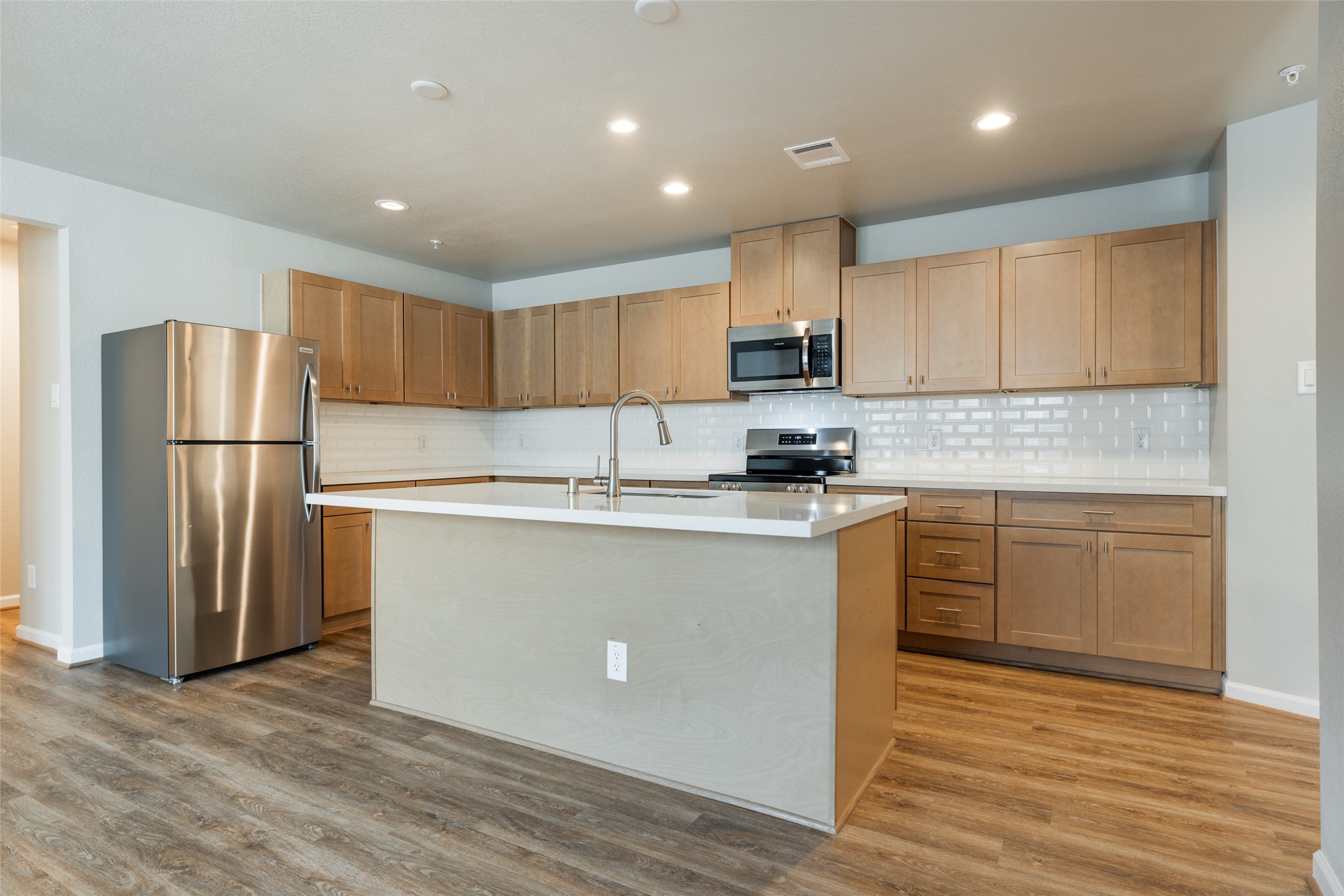 239 Park Place Circle, Unit D Waller, TX 77484 - Photo 9 of 17 a kitchen with kitchen island a counter top space cabinets and stainless steel appliances