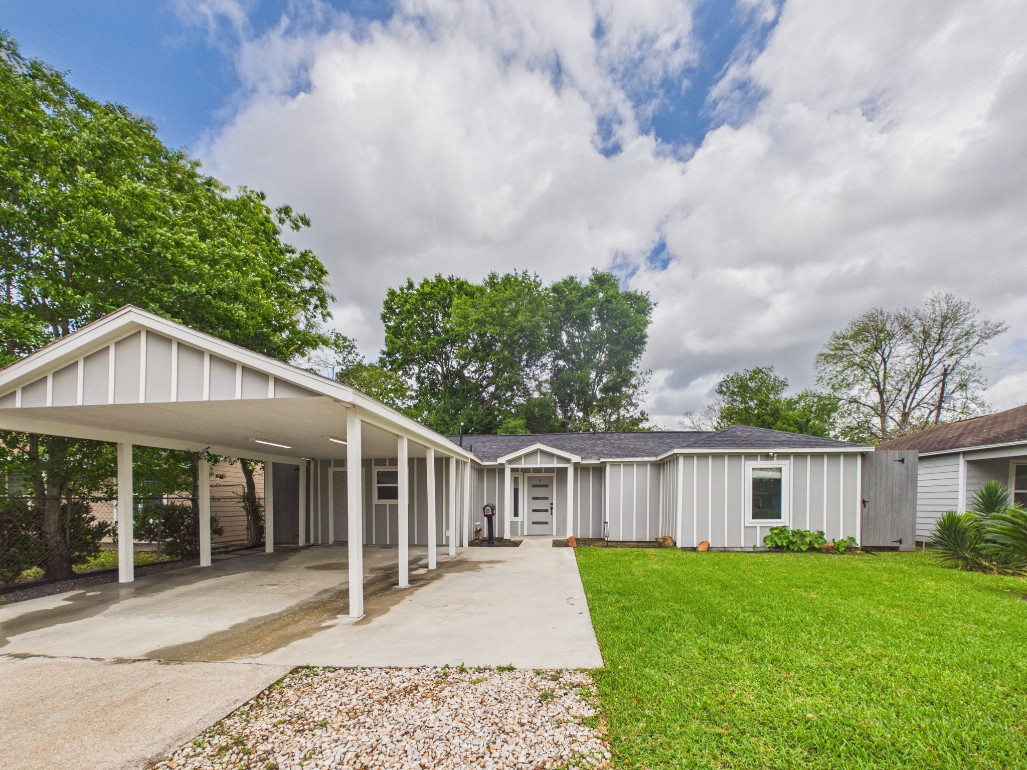 4927 Kelso Street Houston, TX 77021 - Photo 5 of 45 Charming single-story home with modern gray siding and a covered carport. The property features a spacious front yard with well-maintained grass and a gravel walkway, surrounded by mature trees. Ideal for buyers seeking a stylish, low-maintenance exterior.