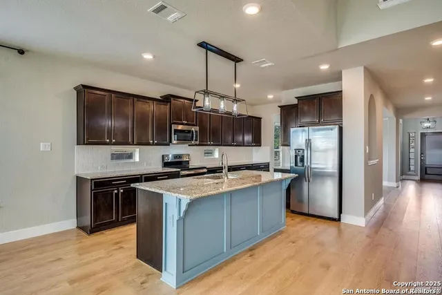 a kitchen with stainless steel appliances granite countertop a sink stove and refrigerator
