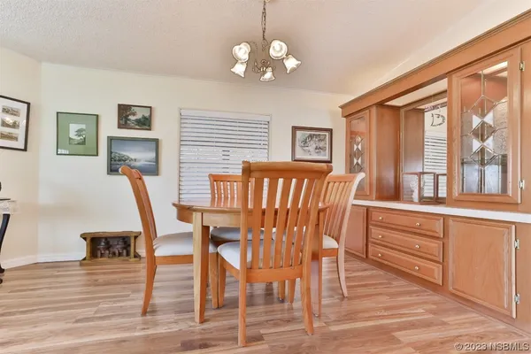 a kitchen with stainless steel appliances a refrigerator a stove a microwave a dining table and chairs with wooden floor