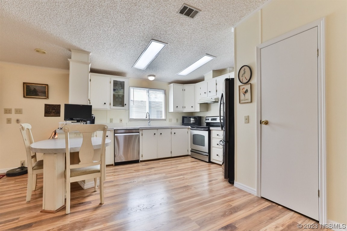 806 Navigators Way Edgewater, FL 32141 - Photo 19 of 59 a kitchen with white cabinets and stainless steel appliances