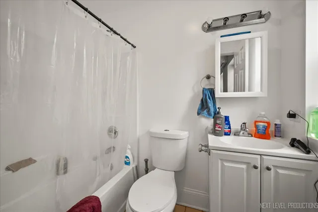 a bathroom with a toilet sink vanity and mirror