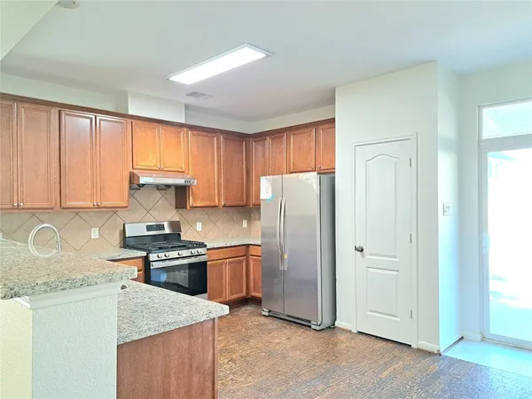 a kitchen with stainless steel appliances granite countertop a refrigerator stove and sink