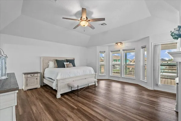 a bedroom with a large bed and wooden floor