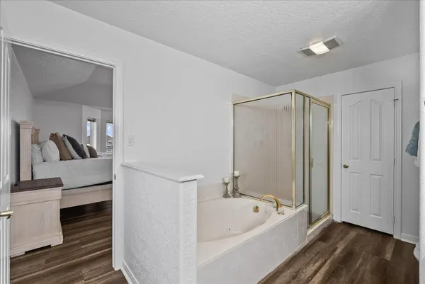 a bathroom with a tub shower and sink