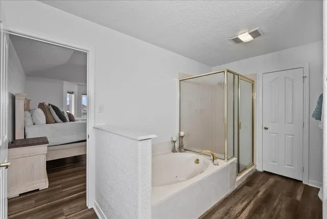 a bathroom with a tub shower and sink