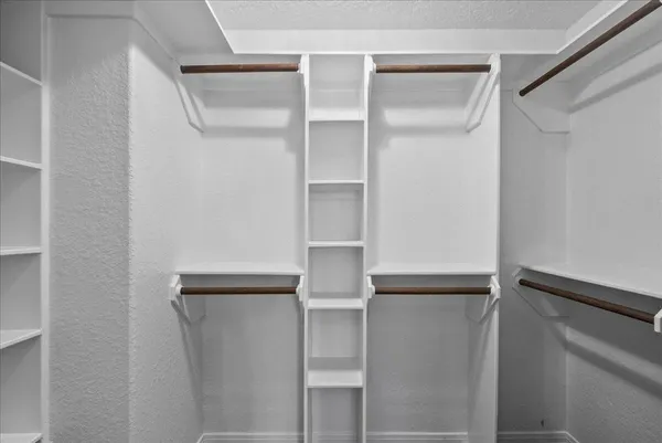 a view of walk in closet with empty racks