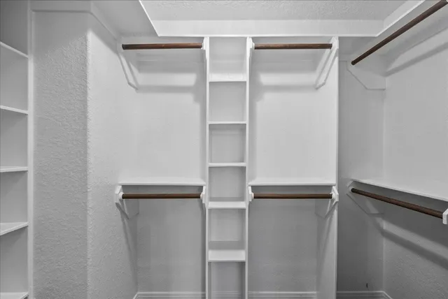 a view of walk in closet with empty racks