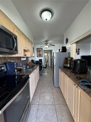 a large kitchen with stainless steel appliances and a stove