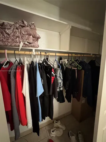a view of walk in closet with clothes and shoes