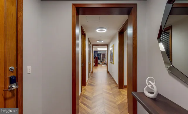 a large kitchen with kitchen island a large counter top a stove a sink a couch and a dining table with wooden floor