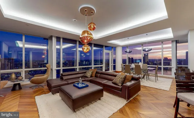 a living room with furniture a chandelier and a large window
