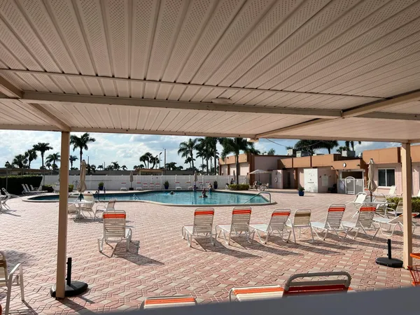 a outdoor patio with swimming pool table and chairs