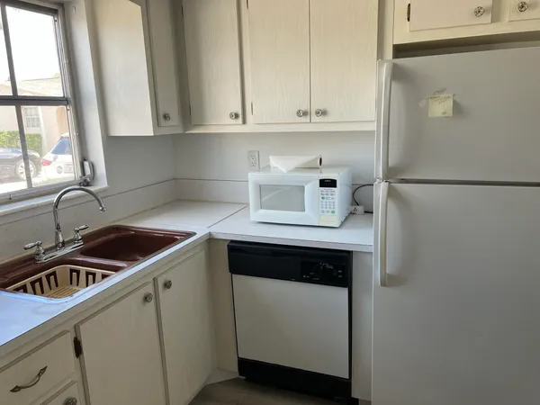 a kitchen with sink a refrigerator and a stove