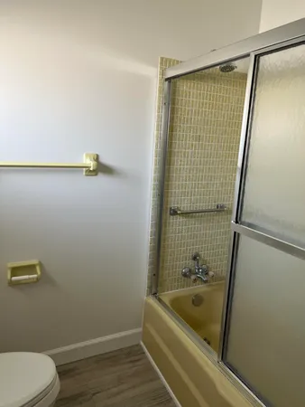 a bathroom with a tub shower and toilet