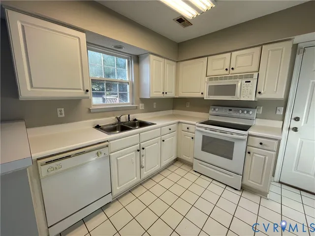 a kitchen with a refrigerator and white cabinets