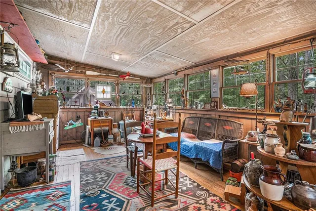 a living room with furniture a rug and a floor to ceiling window