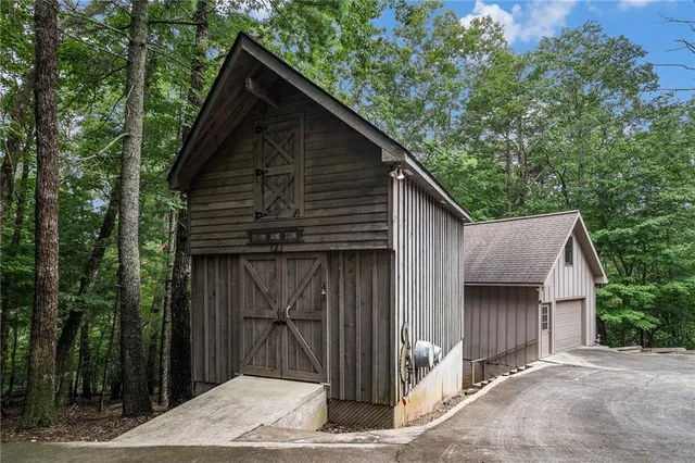 a backyard of a house with large trees and wooden fence