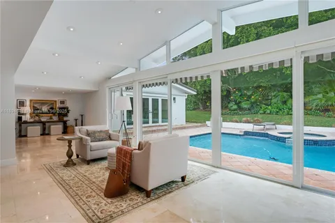 a view of a dining room with furniture large windows and wooden floor
