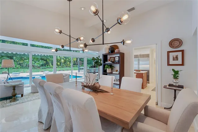 a view of a dining room with furniture large windows and wooden floor