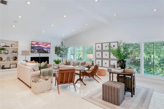 a living room with fireplace furniture and a large window