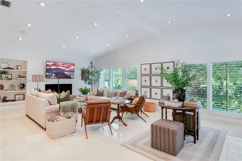 a living room with fireplace furniture and a large window