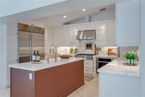 a kitchen with a sink white cabinets and appliances