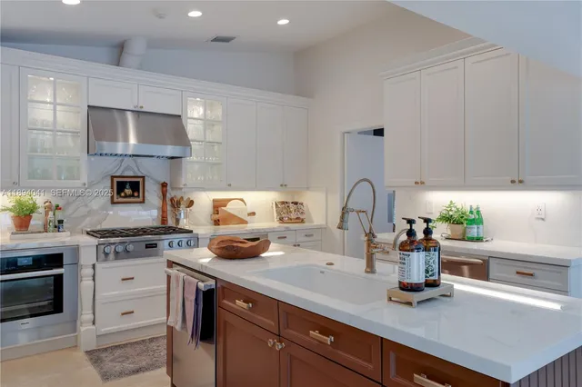 a kitchen with a sink white cabinets and appliances