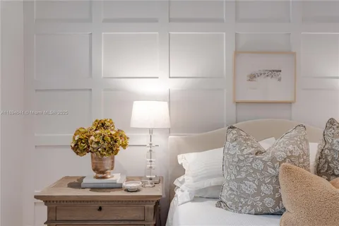 a bedroom with a large bed and a potted plant