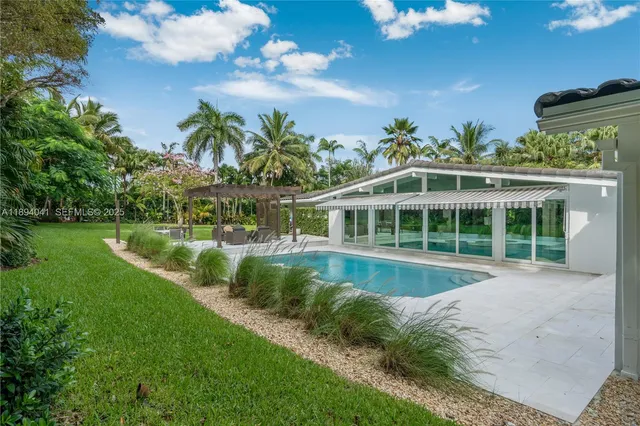 an aerial view of residential house with outdoor space and trees all around