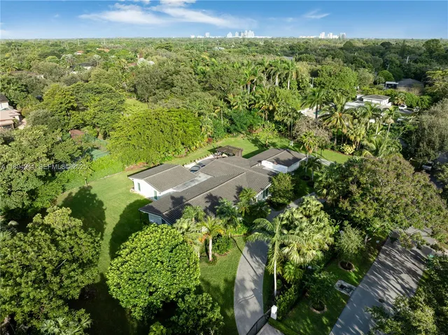 an aerial view of a house with a yard lake and outdoor seating