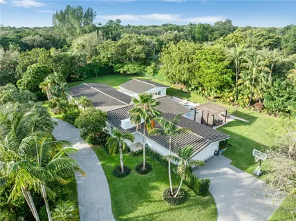 a view of a house with swimming pool and a yard