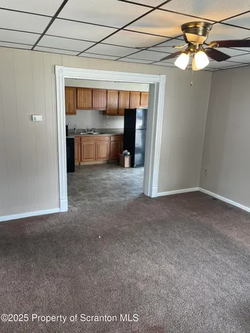 a view of a room with a ceiling fan and window
