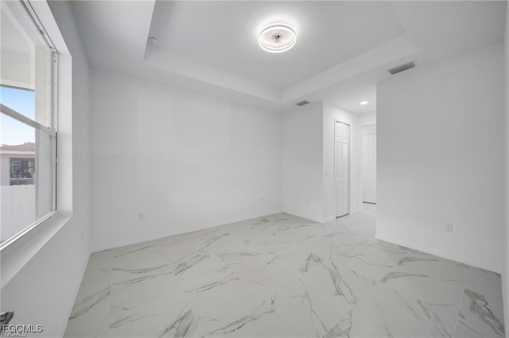 2805 26th Street Southwest Lehigh Acres, FL 33976 - Photo 14 of 27 an empty room with a empty space and windows