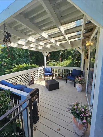 a view of a patio with table and chairs potted plants with wooden floor and fence