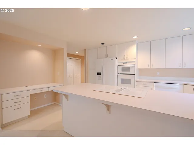 a kitchen with granite countertop a sink cabinets and stainless steel appliances
