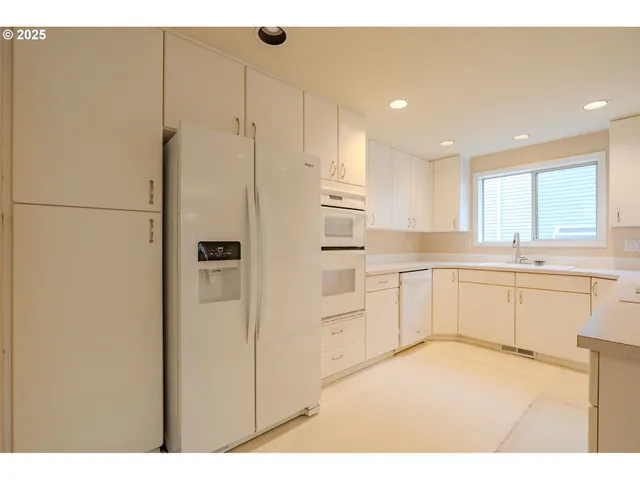 a kitchen with white cabinets and white appliances