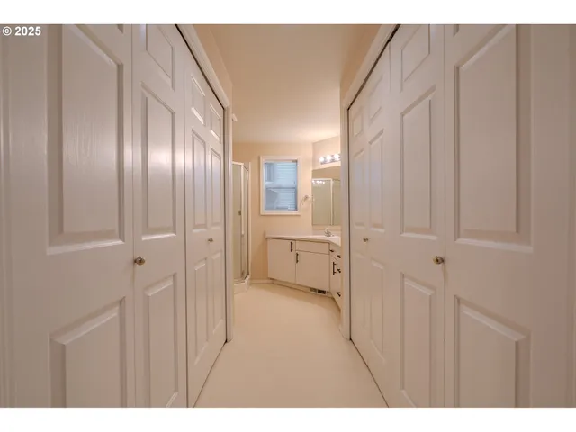 a view of a hallway with wooden cabinets