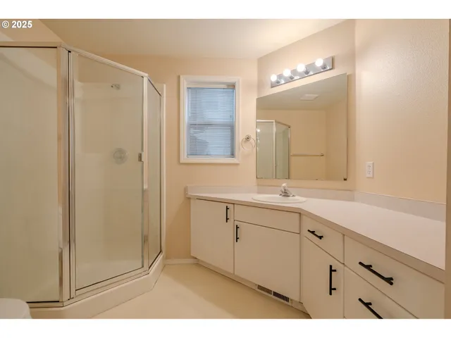 a bathroom with a double vanity sink mirror and shower