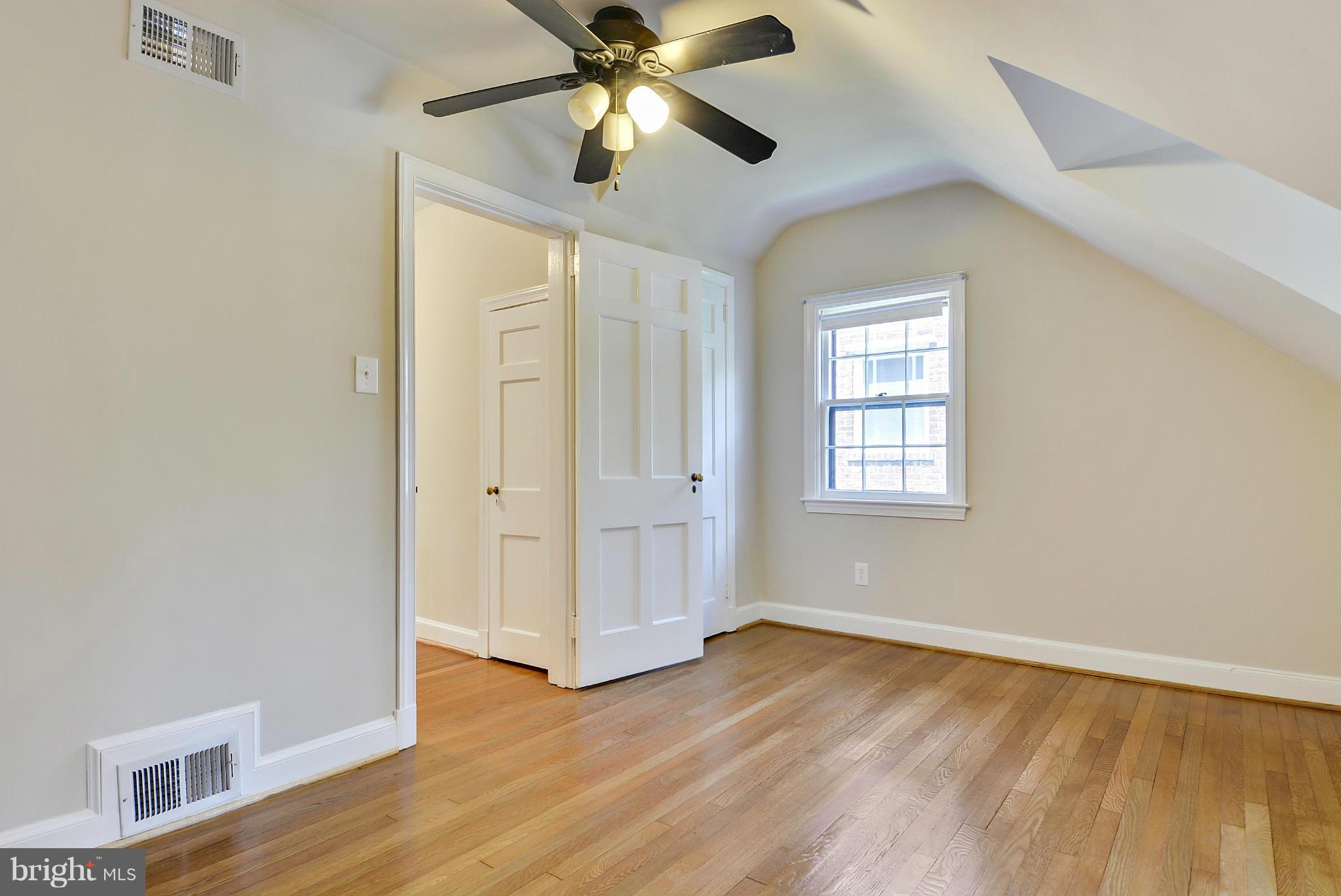 619 Greenbrier Drive Silver Spring, MD 20910 - Photo 20 of 30 an empty room with wooden floor chandelier fan and windows
