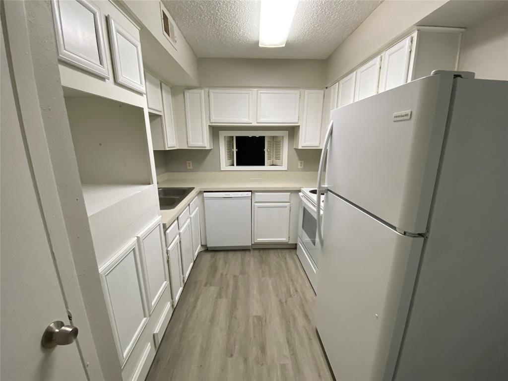 9696 Walnut Street, Unit 708 Dallas, TX 75243 - Photo 4 of 10 a kitchen with white cabinets and white appliances