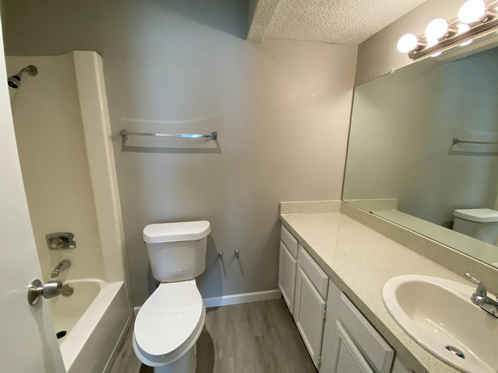 9696 Walnut Street, Unit 708 Dallas, TX 75243 - Photo 8 of 10 a bathroom with a sink a toilet and a mirror