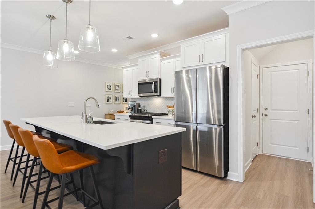 765 Trevett Way Marietta, GA 30066 - Photo 12 of 44 a kitchen with stainless steel appliances a table chairs in it and wooden floors