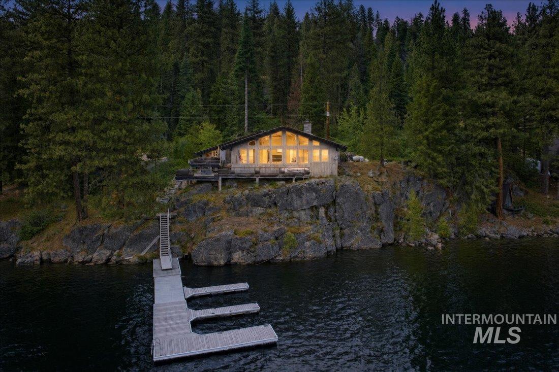 3800 Warren Wagon Road McCall, ID 83638 - Photo 49 of 50 Waterfront property featuring a private dock with multiple slips, a rustic-style residence, an elevated deck, and a densely forested backdrop